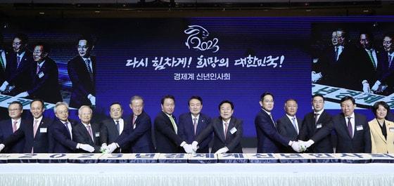 본문 이미지 - 윤석열 대통령과 최태원 대한상의 회장을 비롯한 참석자들이 2일 서울 강남구 코엑스에서 열린 2023년 경제계 신년인사회에서 떡을 자르고 있다.(대한상의 제공) 2023.1.2/뉴스1