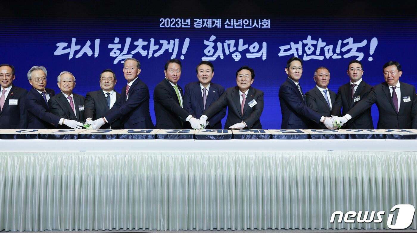 본문 이미지 - 지난해 1월 2일 서울 강남구 코엑스에서 열린 2023년 경제계 신년인사회에서 윤석열 대통령이 참석자들과 떡 케이크를 자르고 있다. (대통령실 제공) 2023.1.2/뉴스1 ⓒ News1 오대일 기자