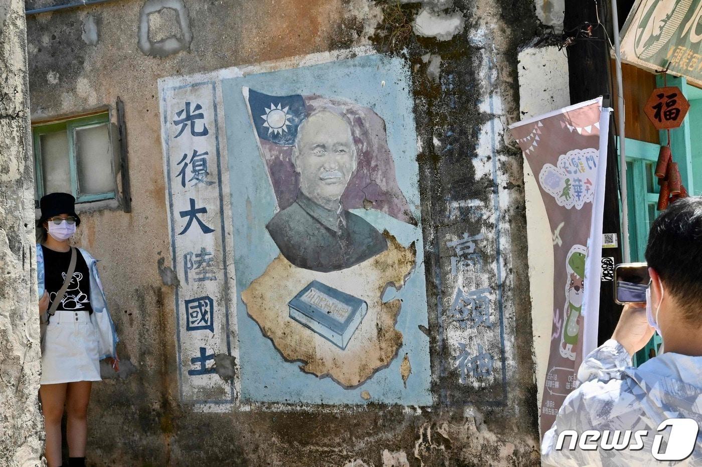 지난해 8월11일 관광객이 대만 진먼섬에서 고(故) 장제스 총통 벽화 옆에서 사진을 촬영하고 있다. 2022.08.11/뉴스1 ⓒ AFP=뉴스1 ⓒ News1 김민수 기자