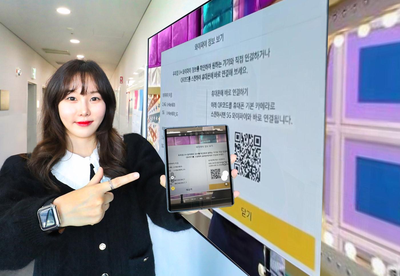 LG유플러스 직원이 U+tv 속 QR코드를 스마트폰 카메라로 촬영해 WiFi를 연결하고 있는 모습. (LGU+ 제공)