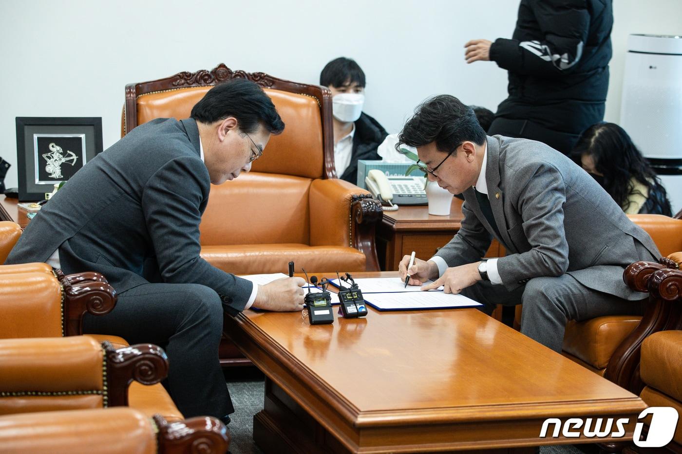 본문 이미지 - 송언석 국민의힘 원내수석부대표(왼쪽)와 진성준 더불어민주당 원내수석부대표가 25일 서울 여의도 국회 운영위원장실에서 임시국회 의사일정 합의문에 서명하고 있다. 2023.1.25/뉴스1 ⓒ News1 유승관 기자