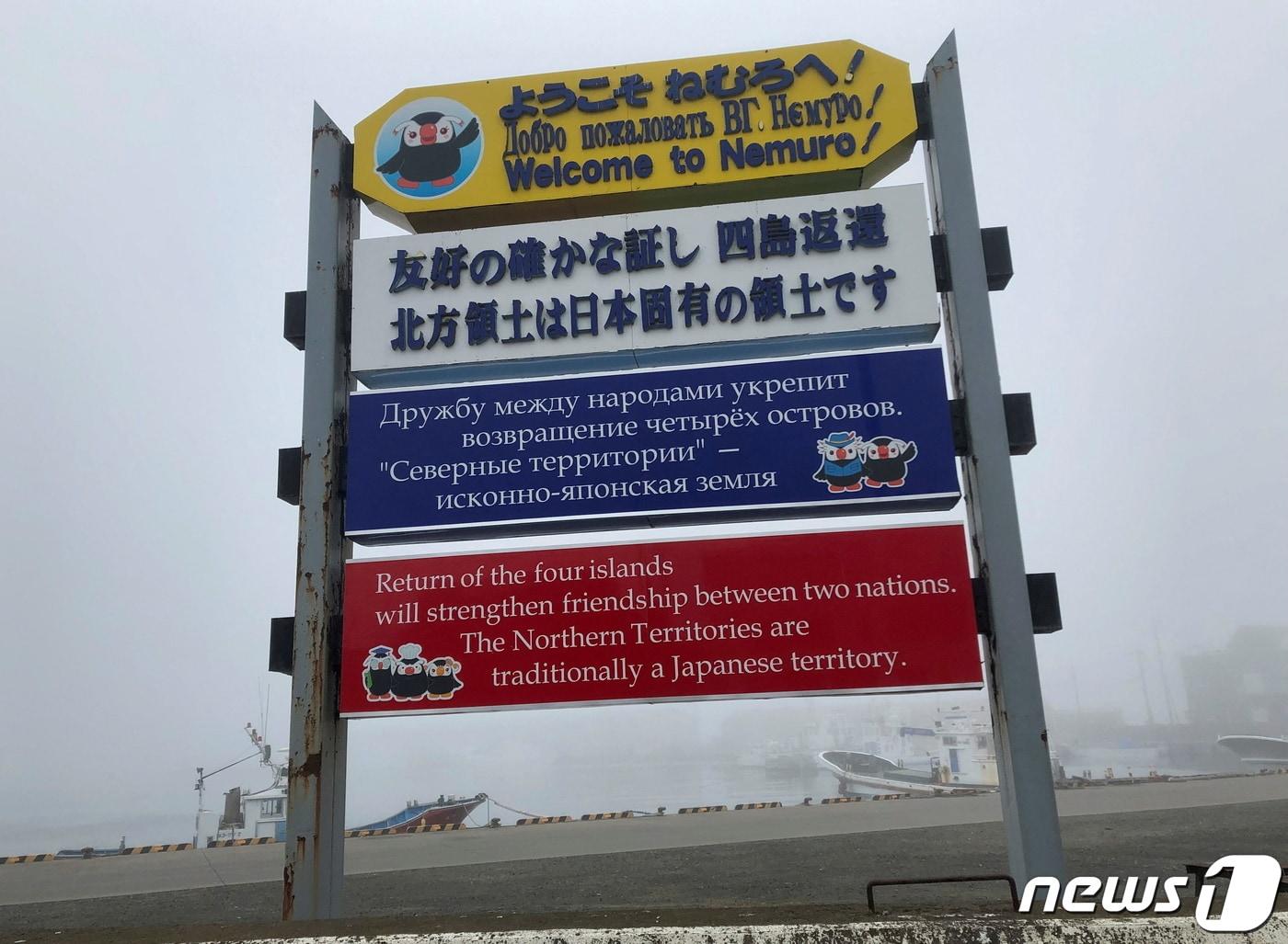 본문 이미지 - 일본 홋카이도 최동단 네무로시 하나사키 항구에 있는 간판. 간판에는 일본어·러시아어·영어로 '북방 4도(러시아식·쿠릴열도) 반환 촉구한다'는 내용이 적혀 있다. 2022.04.12 ⓒ 로이터=뉴스1 ⓒ News1 정윤미 기자