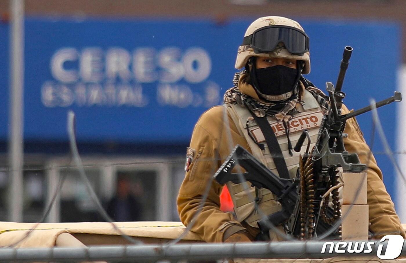 2일(현지시간) 멕시코 치와와주 시우다드후아레스 제3 교도소 앞에서 기관총으로 중무장한 멕시코 군인이 일대를 삼엄하게 경비하고 있다. 이날 현지 당국은 지난 1일 발생한 교도소 무장 습격 사건 사망자가 2명 늘어나 지금까지 총 17명이 숨졌다고 밝혔다. 2023.1.2. ⓒ AFP=뉴스1 ⓒ News1 김성식 기자