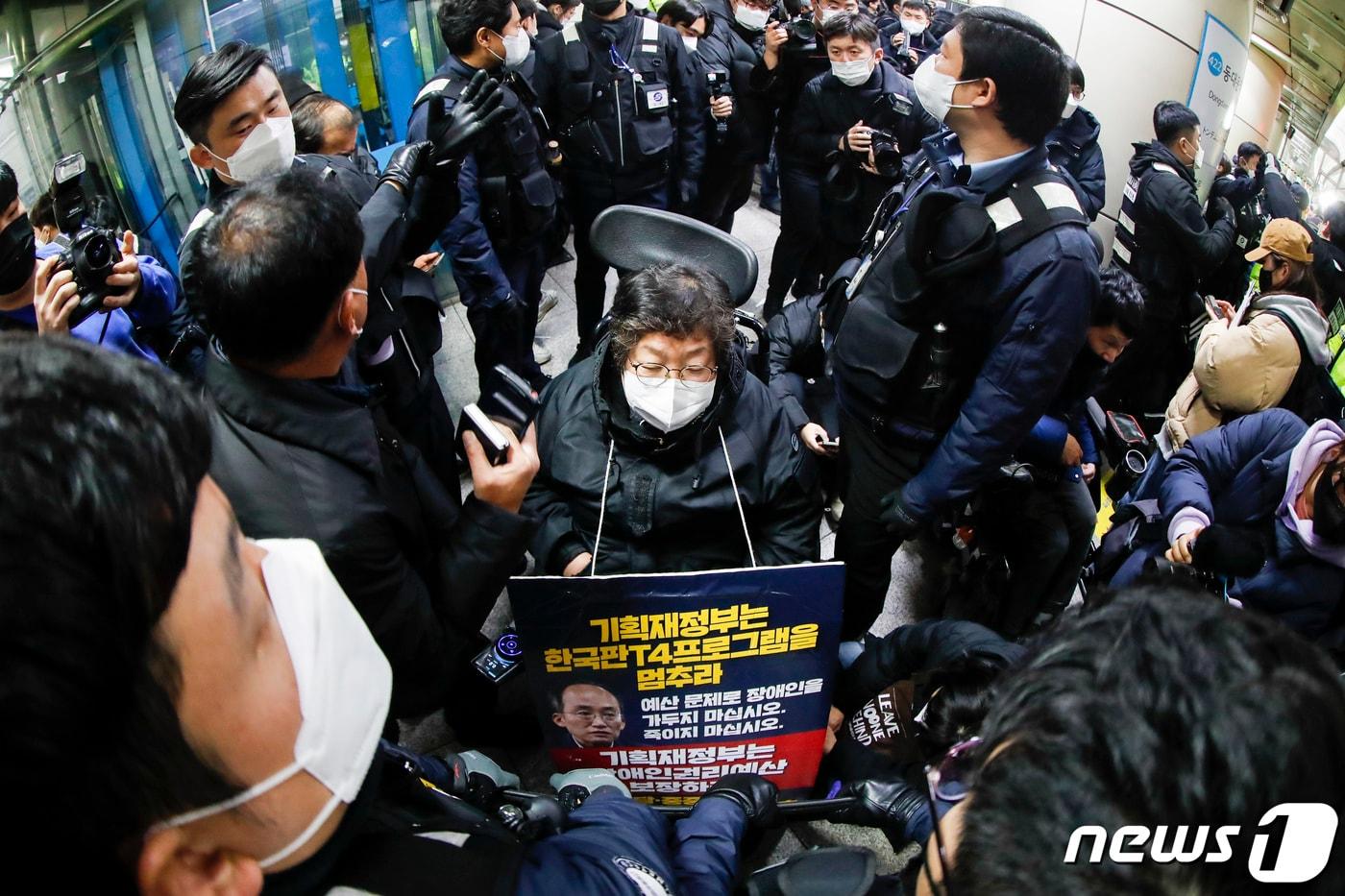 본문 이미지 - 전장연 활동가들이 3일 동대문역사공원역에서 서울교통공사 관계자들과 대치하고 있다. 2023.1.3/뉴스1 ⓒ News1 김도우 기자