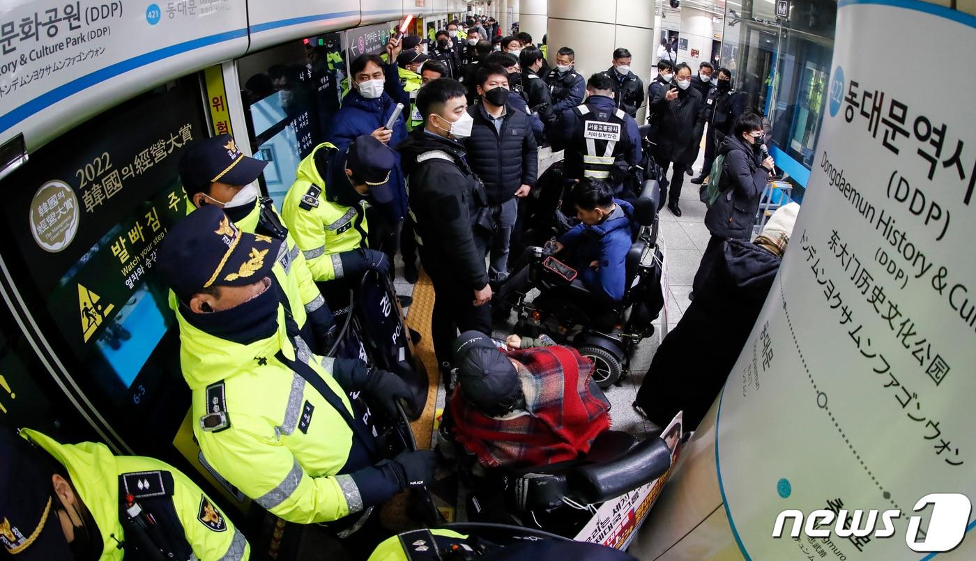 본문 이미지 - 전국장애인차별철폐연대(전장연) 활동가들이 3일 오전 서울 동대문역사공원역에서 지하철 승차를 막는 경찰들과 대치하고 있다. 전장연은 이날 오전 8시 성신여대역에서 기습 선전전을 진행했다. 2023.1.3/뉴스1 ⓒ News1 김도우 기자