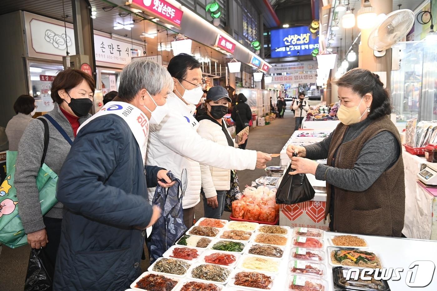 본문 이미지 - 이현재 하남시장(흰색 상의)이 한 재래시장에서 지역화폐 하머니로 물건을 사고 있다.(하남시 제공)