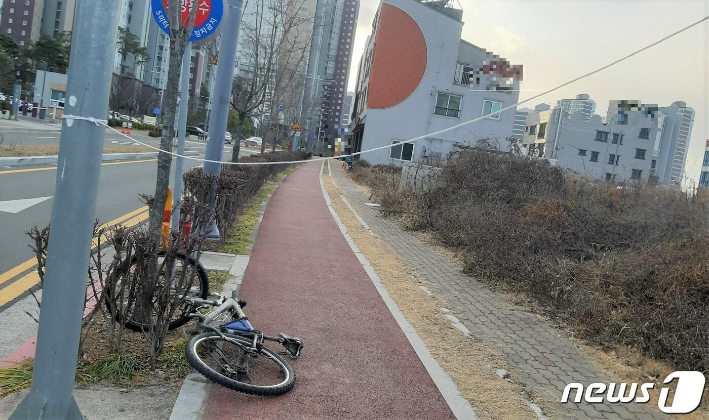 사람 키 높이에 설치된 불법 현수막의 줄과 사고를 당한 자전거. 2023.1.28 뉴스1/한송학기자.