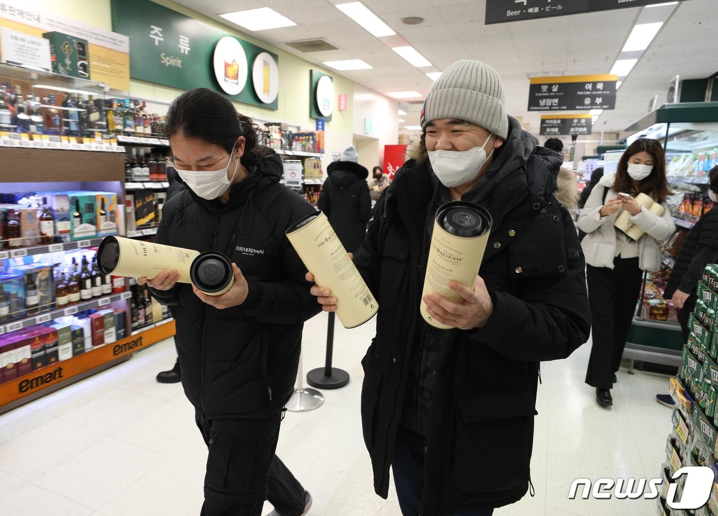 본문 이미지 - 6일 서울 이마트 용산점에서 시민들이 한정판 위스키를 구매한 후 미소 짓고 있다. 이마트는 오는 7일까지 발베니, 맥켈란을 비롯해 2022년 인기 위스키 7종 할인 행사를 진행한다. 2023.1.6/뉴스1 ⓒ News1 신웅수 기자