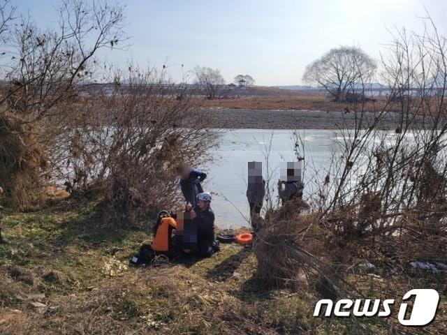 본문 이미지 - 119구급대가 언 강을 건너다 물에 빠진 여성을 응급처치하고 있다. (소방서제공) / 뉴스1