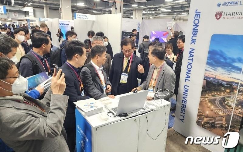 본문 이미지 - 이동원 전북대 교수(사진 맨 오른쪽)가 미국 라스베이거스에서 열린 ‘CES 2023’에서 현재 하버드 의대와 손잡고 공동 연구 개발 중인 ‘혈전탐지 이미징 시스템’ 을 설명하고 있다.(전북대 제공)/뉴스1