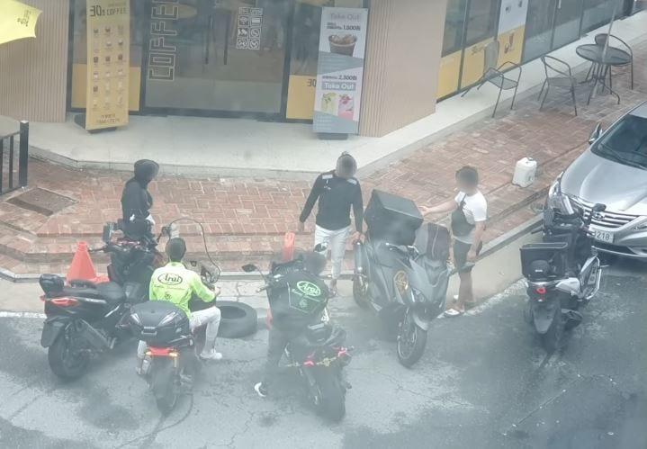 본문 이미지 - 대전의 한 가게 앞에 번호판을 부착하지 않은 오토바이 운전자들이 모여있다. (유튜브 '딸배헌터' 갈무리)