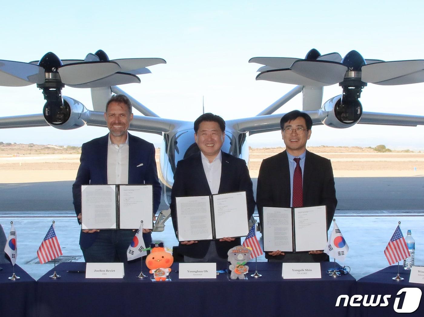 본문 이미지 - 10일 오후(현지시간) 미국 캘리포니아주 조비 생산공장에서 제주도·조비·SK텔레콤이 대한민국 UAM 서비스 시작을 위한 3자간 파일럿 프로젝트 MOU를 체결했다. 조벤 비버트 조비 창립자 겸 대표, 오영훈 제주지사, 신용식 SKT 부사장이 협약서를 들고 기념촬영을 하고 있다.(제주도 제공)/뉴스1