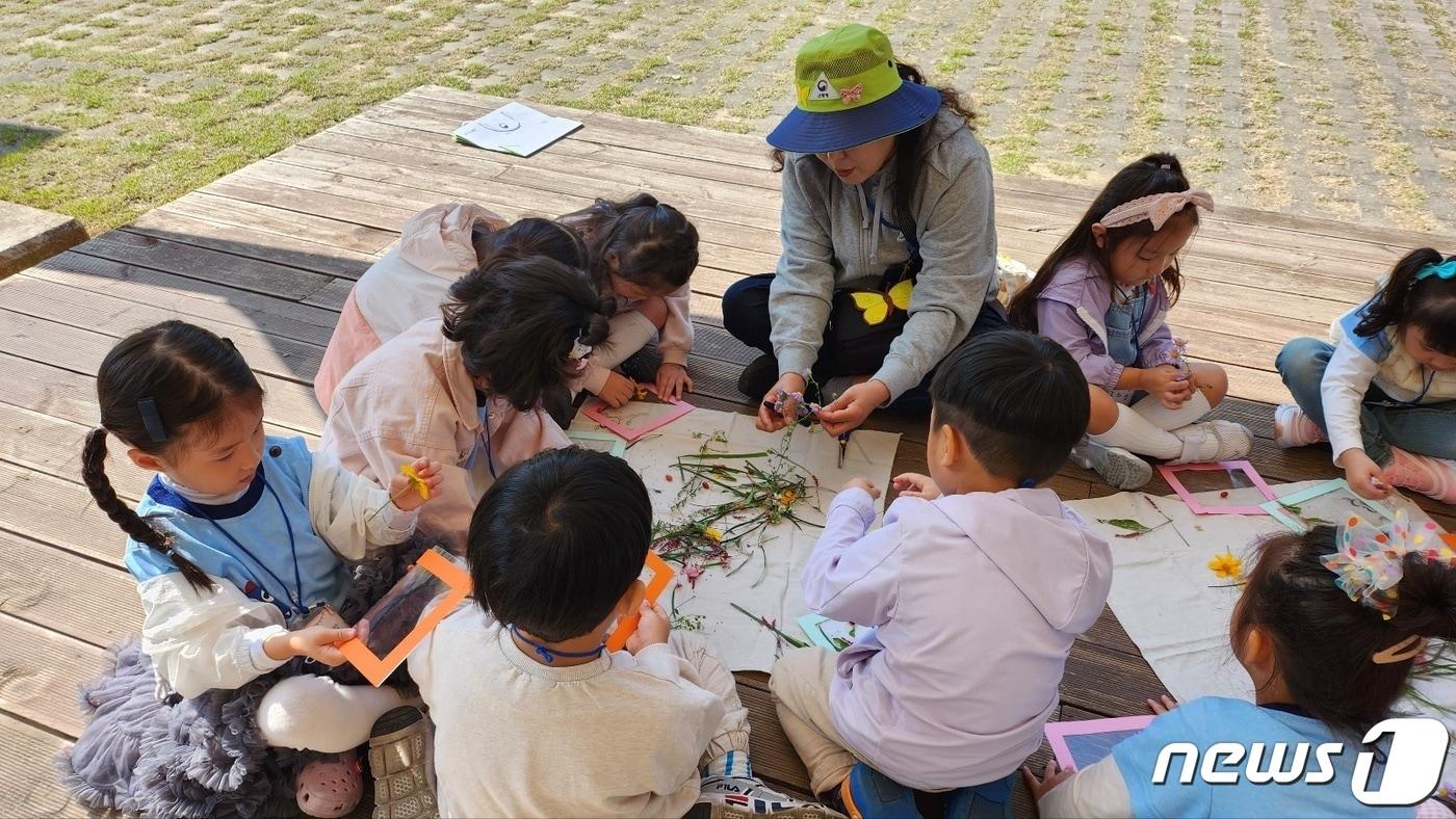 본문 이미지 -  14일 산림청 산림품종관리센터가 채종원에서 가을 숲 체험을 제공한다고 밝혔다. 사진은 유아 나뭇잎 놀이 모습.(산림품종관리센터 제공)2023.10.14/뉴스1