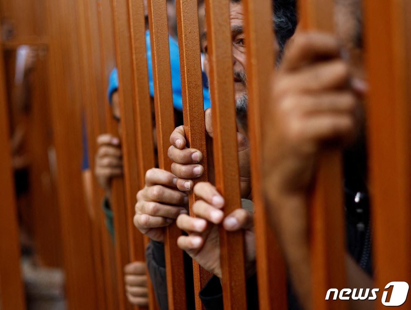 본문 이미지 - 조문객들이 17일(현지시간) 가자지구 알 알리 아랍 병원 공습으로 칸 유니스 병원으로 옮겨진 시신을 바라보며 철문을 꽉 쥐고 있다. 2023.10.17/ ⓒ 로이터=뉴스1 ⓒ News1 권진영 기자