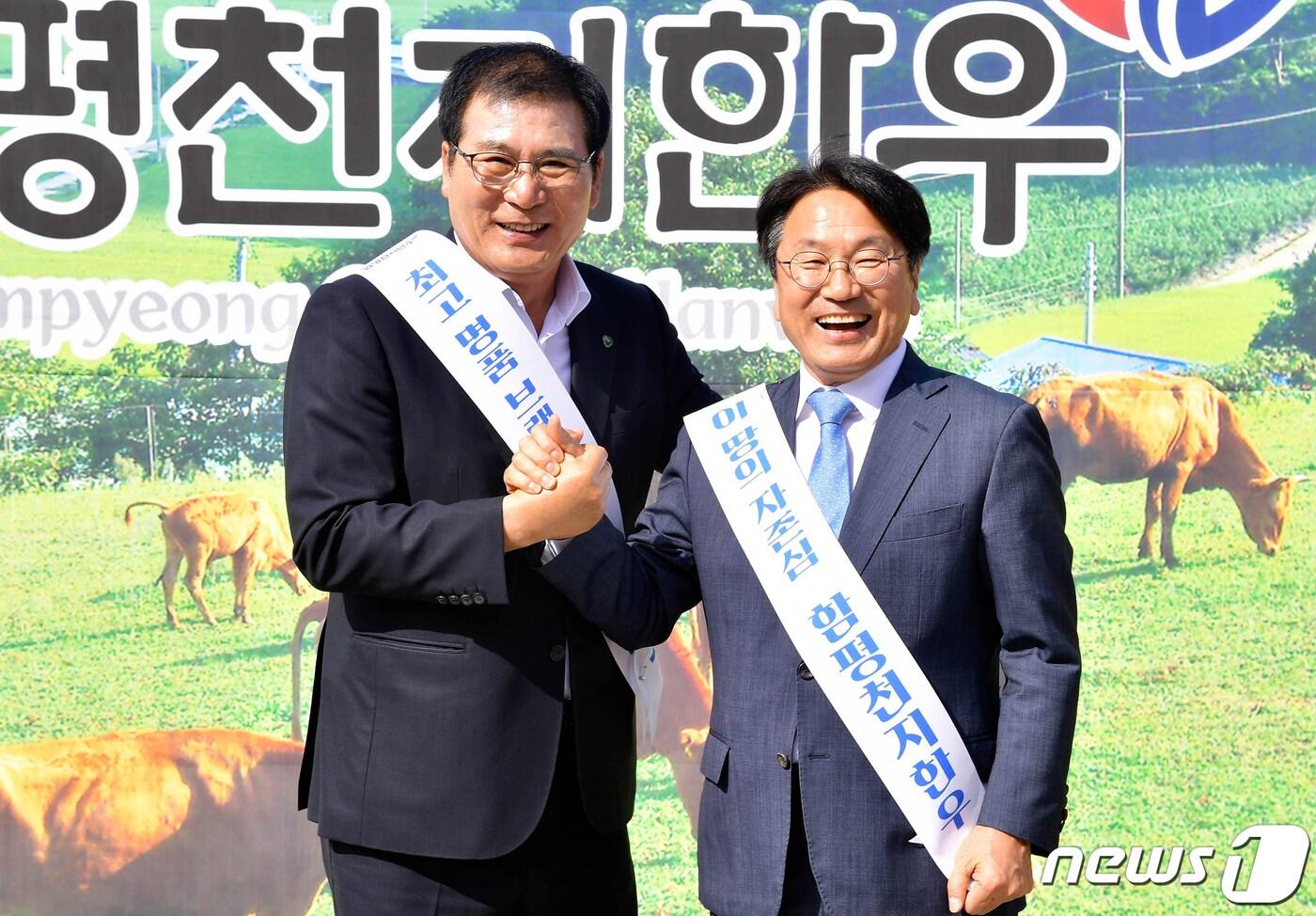 본문 이미지 - 강기정 광주시장(오른쪽)과 이상익 함평군수가 18일 오후 시청 앞 잔디광장에서 열린 '함평천지한우 시식회와 할인판매' 행사에 참석해 손을 맞잡고 있다. (광주시 제공) 2023.10.18/뉴스1
