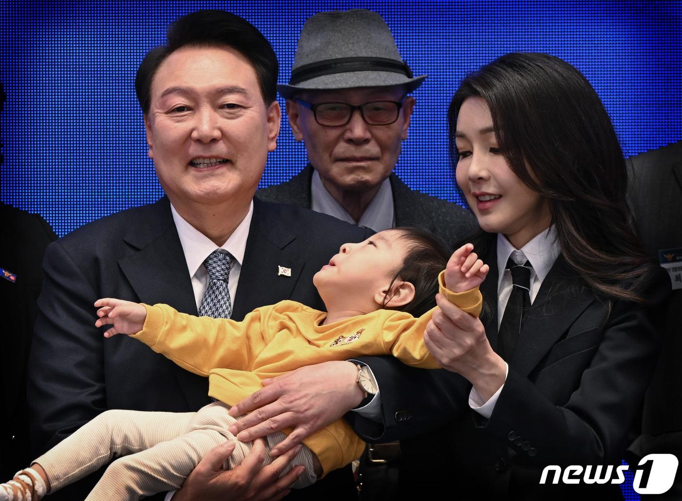 본문 이미지 - 윤석열 대통령과 김건희 여사가 18일 청와대 영빈관에서 열린 제78주년 경찰의날 기념식에서 2020년도 경찰영웅 유재국 경위의 자녀를 안아주며 순직 경찰 유가족들과 기념 촬영을 하고 있다. (대통령실 제공) 2023.10.18/뉴스1 ⓒ News1 오대일 기자