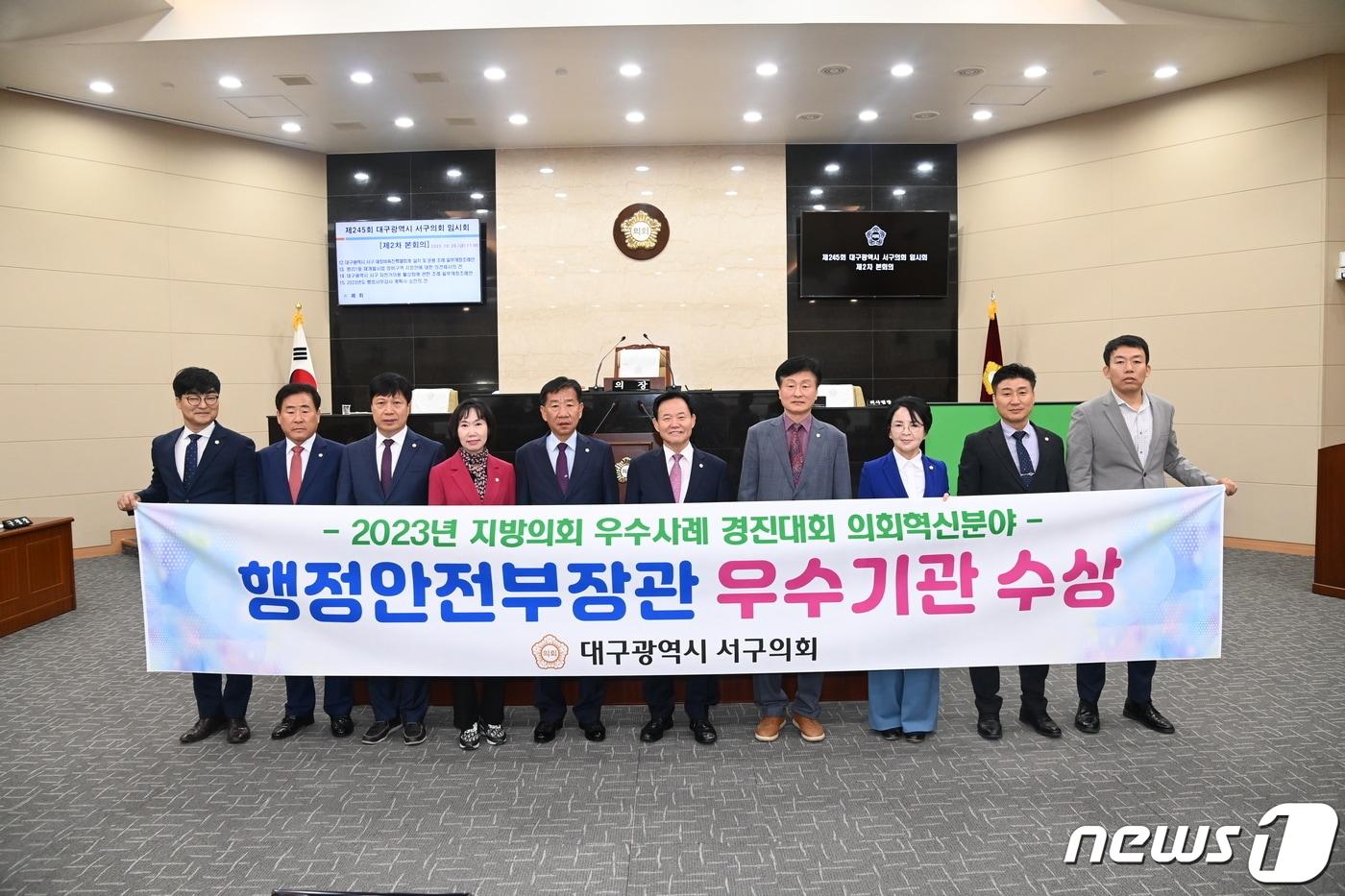 본문 이미지 - 대구 서구의회 관계자들이 지방의회 우수사례 경진대회 의회혁신분야에서 행정안전부 장관상을 수상해 기념촬영을 하고 있다. (대구 서구의회 제공)