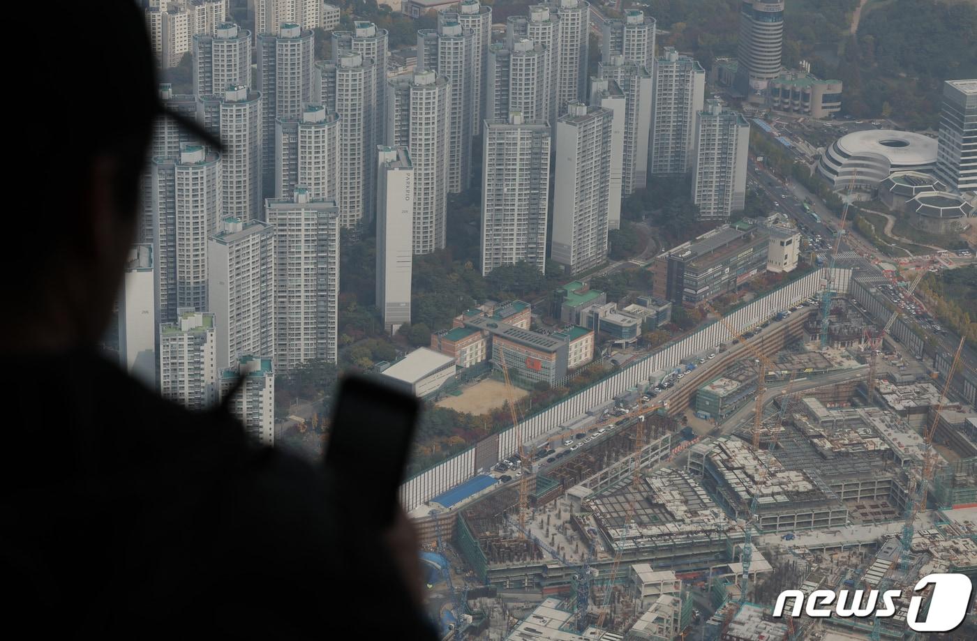 본문 이미지 -  24일 서울 송파구 서울스카이를 찾은 관람객들이 전망대 너머 아파트 단지와 재건축 진행 단지를 바라보고 있다.. 2023.10.24/뉴스1 ⓒ News1 박정호 기자