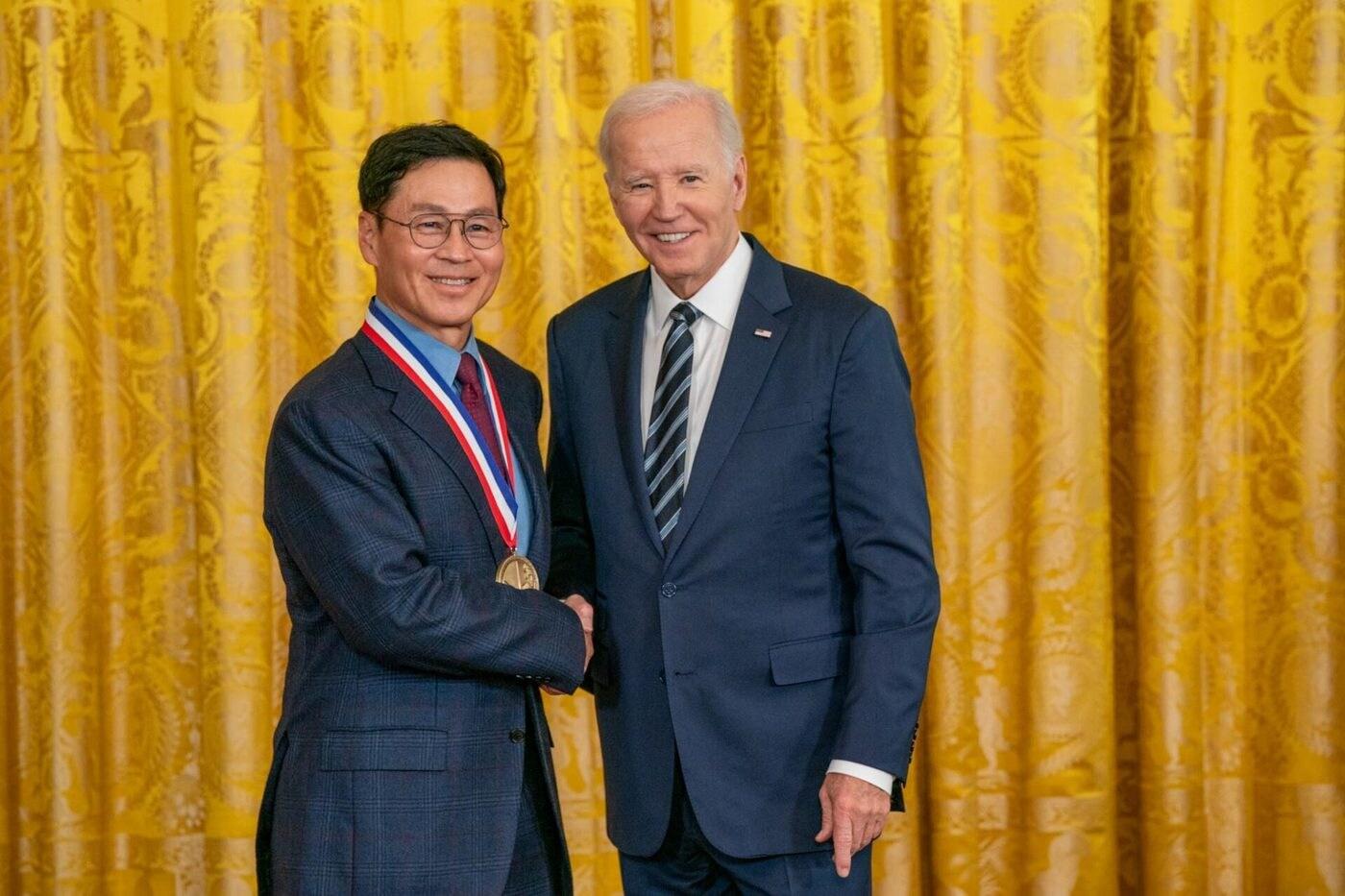 본문 이미지 - 조 바이든 미국 대통령이 24일 백악관 이스트룸에서 열린 시상식에서 김종훈 삼성전자 사외이사에게 국가기술혁신훈장을 수여하고 있다. (NSTMF 제공)