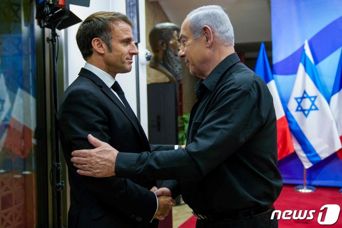 에마뉘엘 마크롱 프랑스 대통령이 24일(현지시간) 예루살렘을 방문해 베냐민 네타냐후 이스라엘 총리와 회담에 앞서 악수를 하고 있다. 2023.10.25 ⓒ AFP=뉴스1 ⓒ News1 우동명 기자