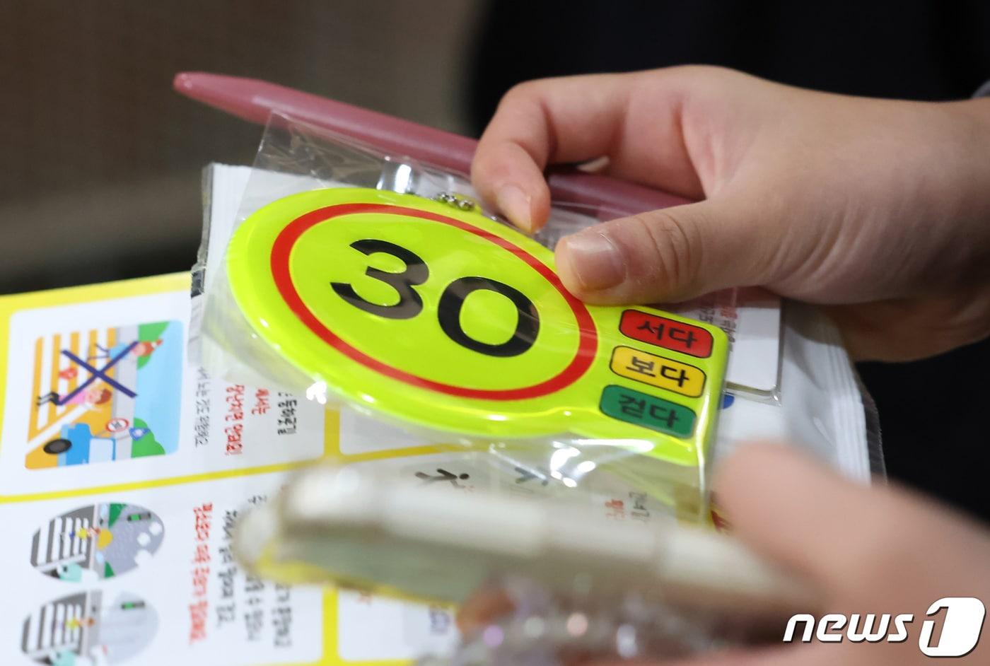 본문 이미지 - '어린이보호구역 시속 30km 이하 운행'을 나타내는 가방고리. ⓒ 뉴스1