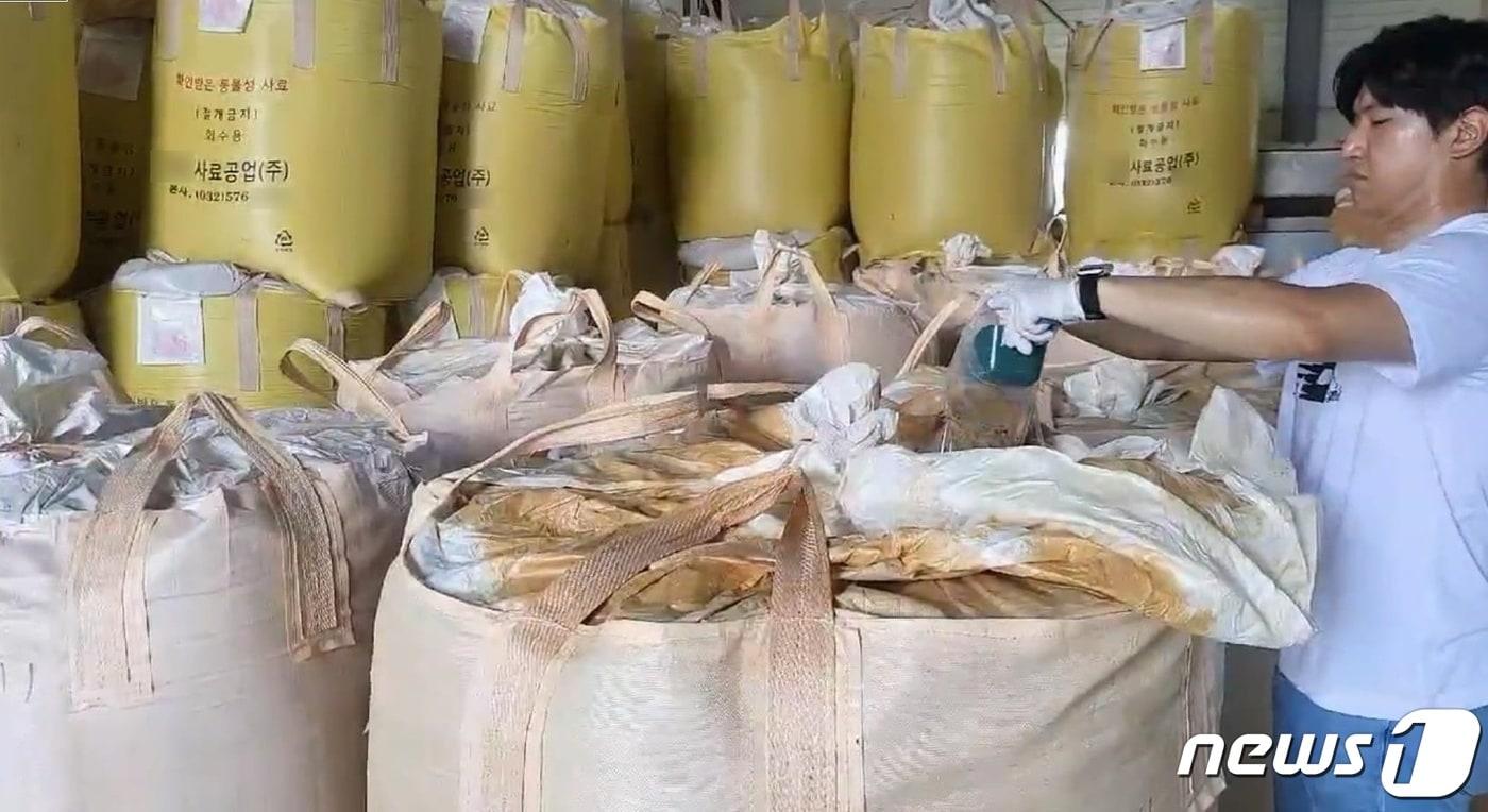 서귀포해경이 제조업체 사료포대에서 국과수에 의뢰할 시료를 채취하고 있다.(서귀포해양경찰서 제공)