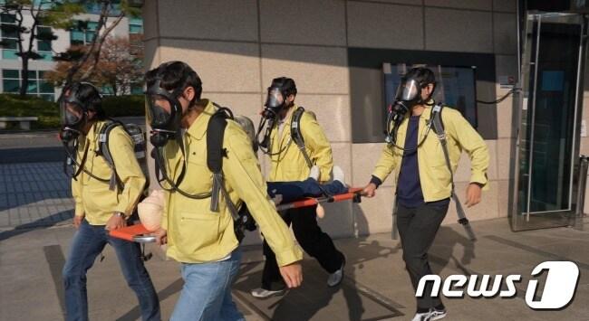 본문 이미지 - 한국지질자원연구원 관계자들이 지질박물관 화재 대피 현장훈련에서 인명구조를 하고 있다.(지질자원연 제공)/뉴스1