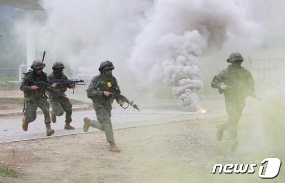 본문 이미지 - 제1회 '국제 과학화전투 경연대회'에 참가한 우리 육군 장병들이 대항군 부대가 점령한 건물을 확보하기 위해 약진하고 있다. (육군 제공)