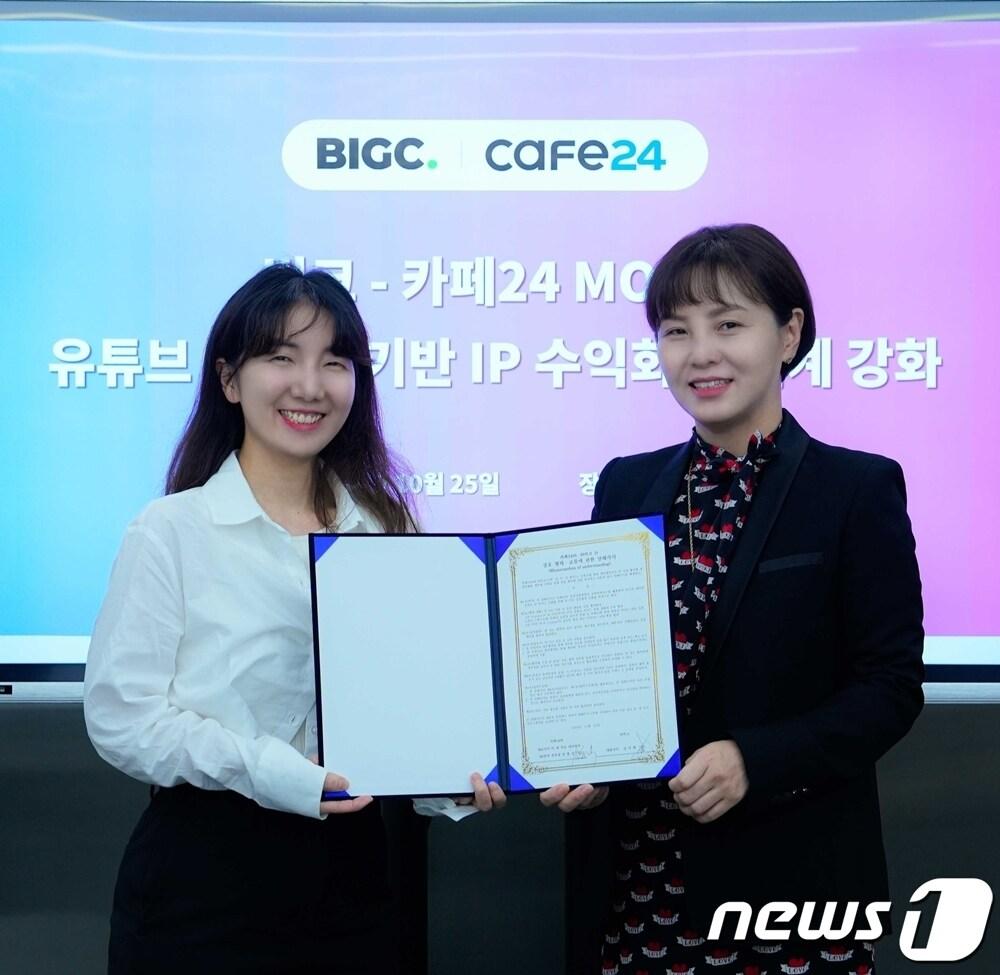 본문 이미지 - 송종선 카페24 마케팅이노베이션(MI) 본부장(오른쪽)과 김미희 빅크 대표가 유튜브 커머스 기반 IP 수익화 생태계 성장을 위한 업무협약(MOU)을 체결했다.(카페24 제공)