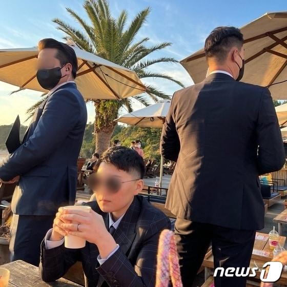 본문 이미지 - 전청조(가운데)씨가 제주도 모 카페에서 경호를 받고 있는 모습(김민석 강서구 의원 제공)