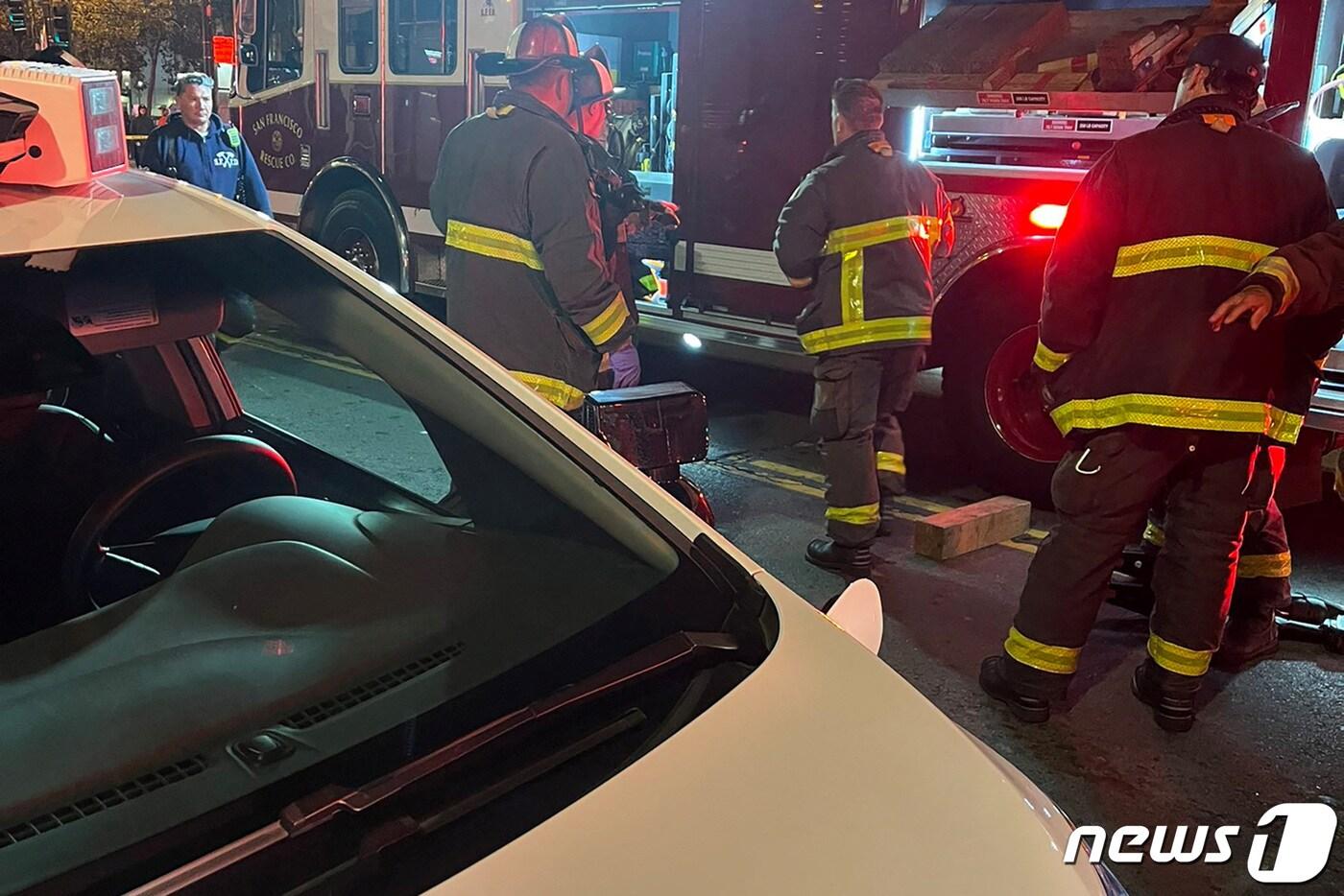 미국 샌프란시스코 시내에서 2일(현지시간) 제너럴모터스(GM)의 자율주행 무인택시(로보택시) '크루즈'가 신호를 어기고 교차로를 건너던 보행자 1명을 들이받아 중상을 입히는 사건이 발생했다. 사진은 출동한 구조대원들이 차량에 깔린 여성을 구출하는 모습. 2023.10.2. ⓒ 로이터=뉴스1 ⓒ News1 김성식 기자