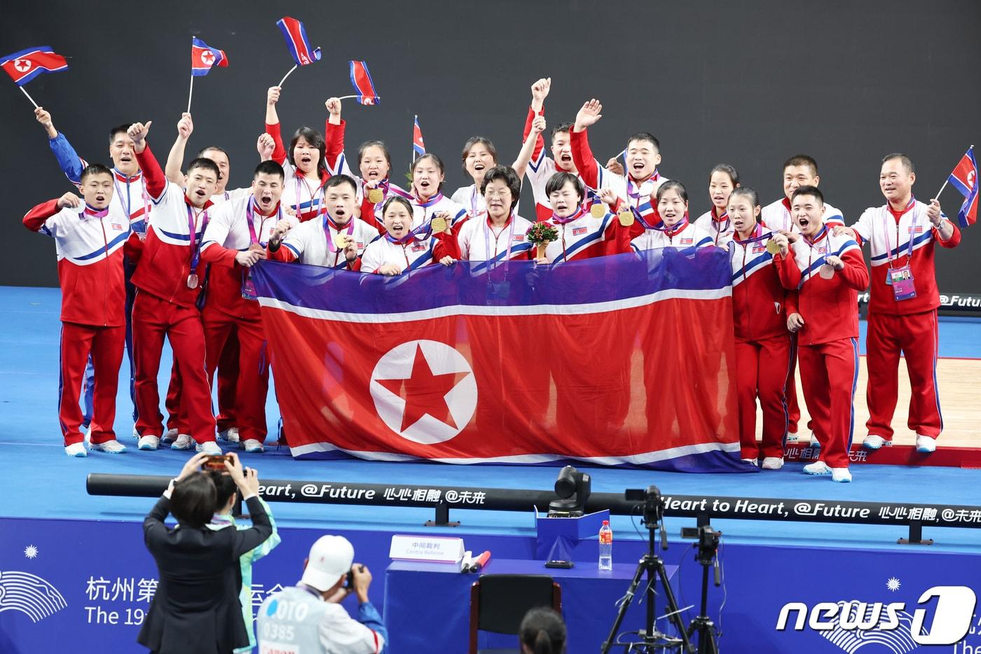 본문 이미지 - 지난 2023년에 열린 항저우 아시안게임 여자 역도 76kg급 그룹 A 결선에서 북한의 송국향과 정춘희가 각각 금메달과 은메달을 목에 건 뒤 북한의 메달리스트들이 모두 모여 기념촬영을 하고 있다. 2023.10.5 ⓒ 뉴스1 민경석 기자