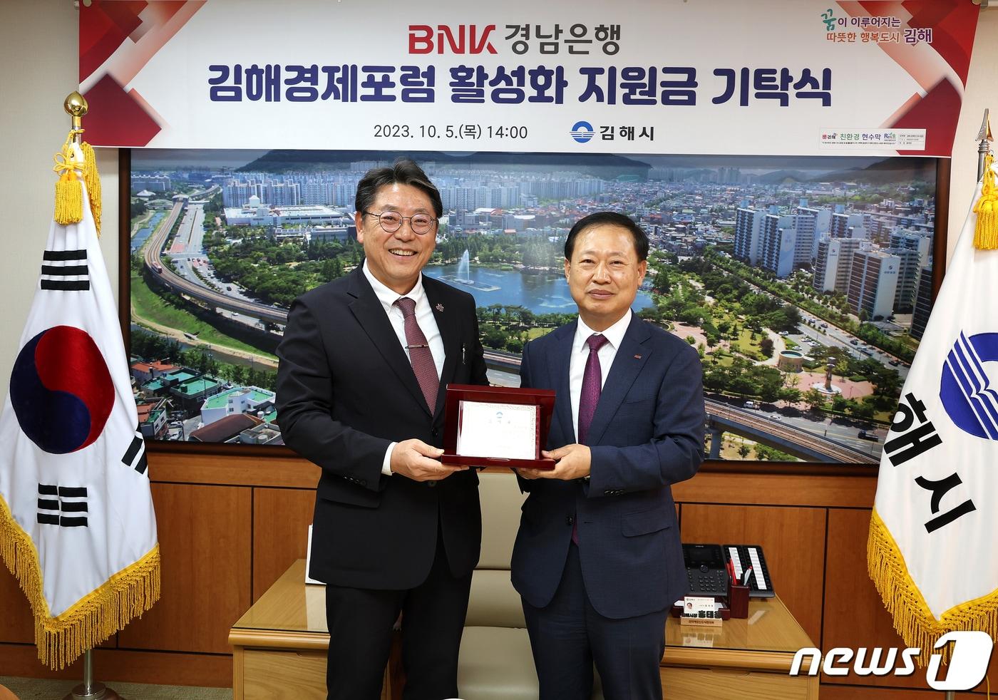 본문 이미지 - 경남은행 관계자가 김해시에 김해경제포럼 활성화 지원금을 기탁하고 홍태용 김해시장(왼쪽)과 기념사진을 찍고 있다.(김해시 제공)
