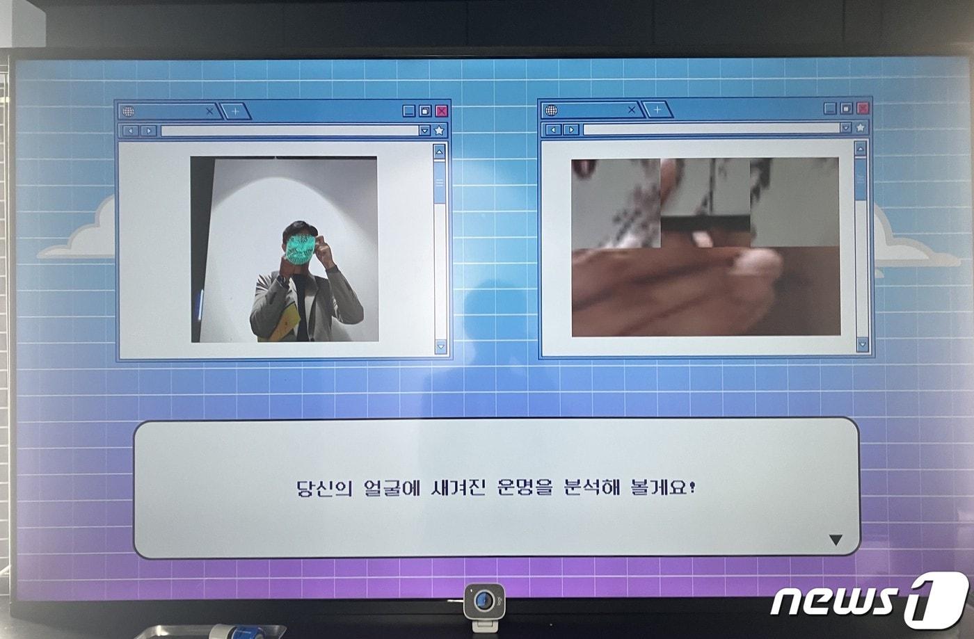 6일 서울 잠실 롯데시네마 월드타워 7층 '랜덤스퀘어'에서 열린 '랜덤 데스티니 2023' 전시에서 취재기자가 AI 관상 분석 부스에서 사진을 촬영하고 있다. 화면 우측에는 모니터 앞에 설치된 카메라로 관람객의 얼굴 각 부위를 찍은 사진이 나온다. 2023.10.6./ⓒ 뉴스1 김기성 기자