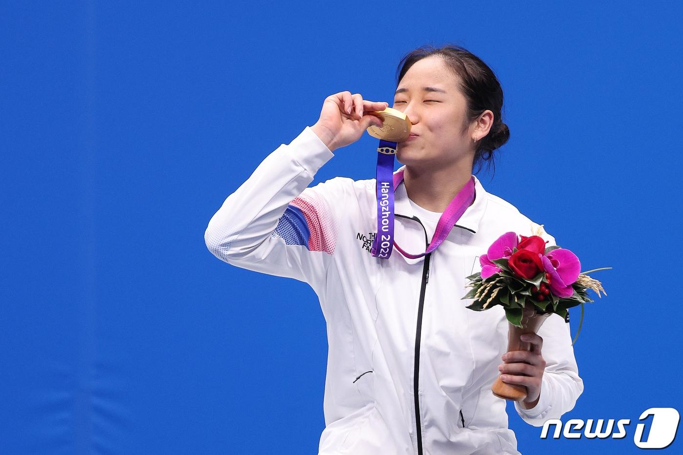 본문 이미지 - 안세영이 7일 중국 항저우 빈장체육관에서 열린 2022 항저우 아시안게임 배드민턴 여자 단식 메달 수여식에서 금메달에 키스를 하고 있다. 2023.10.7 ⓒ 뉴스1 신웅수 기자