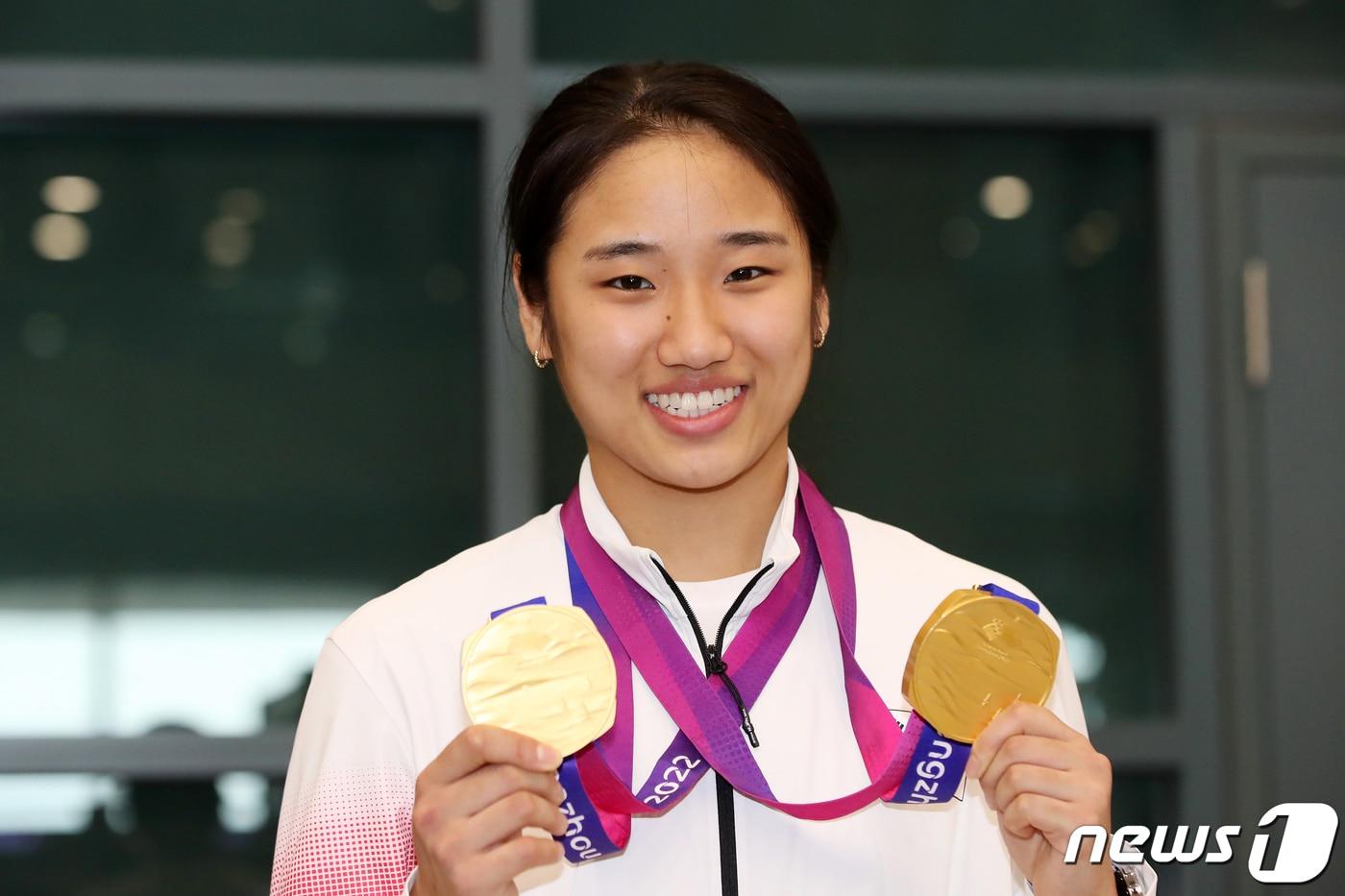 본문 이미지 - 배드민턴 여제 안세영이 제19회 항저우 아시안게임을 마치고 8일 오후 인천국제공항을 통해 귀국해 메달을 들고 포즈를 취하고 있다. 안세영은 항저우 아시안게임에서 배드민턴 여자 단식, 여자 단체전에서 금메달을 따내며 2관왕에 등극했다. 2023.10.8 ⓒ 뉴스1 이승배 기자