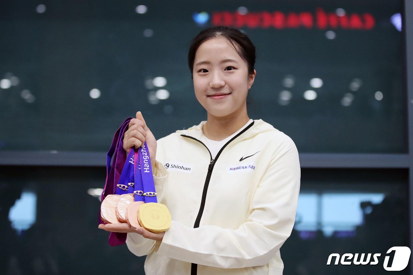 본문 이미지 - 제19회 항저우 아시안게임 탁구 여자 복식에서 전지희와 함께 금메달을 획득한 신유빈이 8일 오후 인천국제공항을 통해 귀국해 메달을 들고 기념촬영하고 있다. 신유빈은 항저우 아시안게임에서 탁구 여자 복식 금메달, 여자 단체전·여자 단식·혼합 복식에서 각각 동메달을 따냈다. 2023.10.8/뉴스1 ⓒ News1 이승배 기자