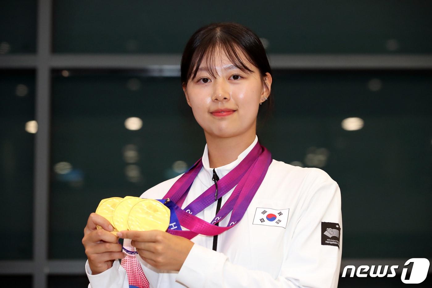 본문 이미지 - 제19회 항저우 아시안게임 양궁 3관왕을 기록한 임시현이 8일 오후 인천국제공항을 통해 귀국해 메달을 들고 기념촬영하고 있다. 2023.10.8/뉴스1 ⓒ News1 이승배 기자