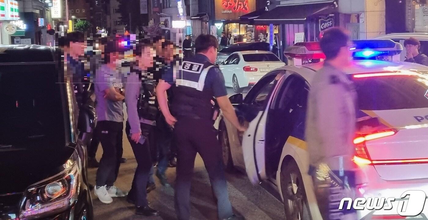 본문 이미지 - 8일 밤 강원 춘천의 한 먹자골목에서 흉기를 들고 배회한 남성을 경찰이 붙잡아 임의동행하고 있다.(독자제공) 2023.10.8/뉴스1