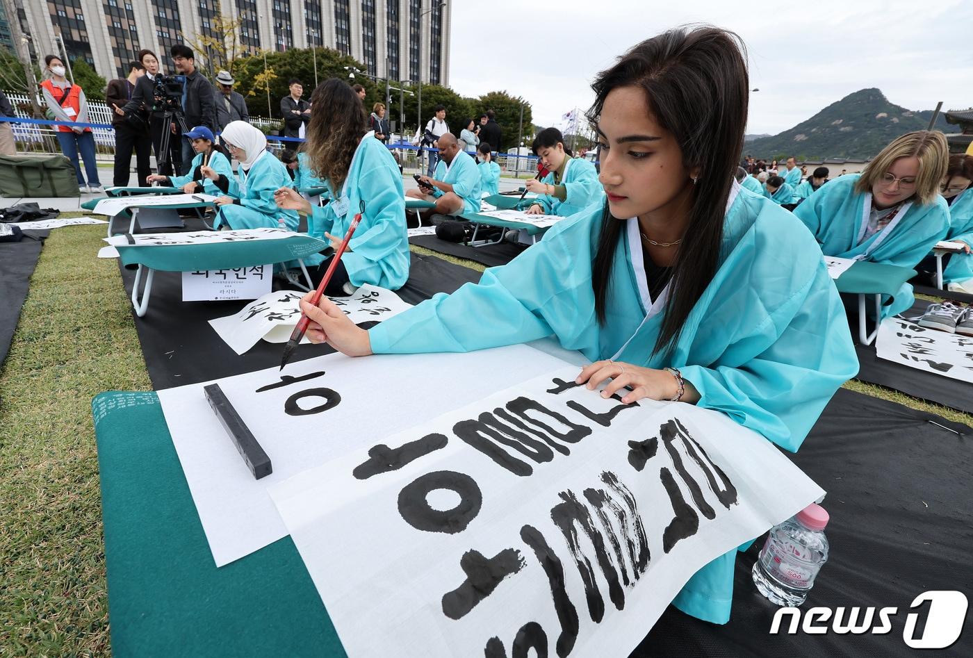 본문 이미지 - 577돌 한글날인 9일 오전 서울 광화문광장에서 열린 휘호경진대회에서 참가자들이 정성스럽게 글씨를 써내려가고 있다. 2023.10.9/뉴스1 ⓒ News1 이동해 기자