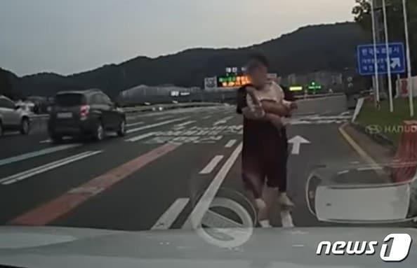 본문 이미지 -  지난달 4일 오후 6시께 대전톨게이트 인근 고속도로에서 맨발로 뛰어다니는 아이를 구조한 운전자. (유튜브 '한문철 TV')
