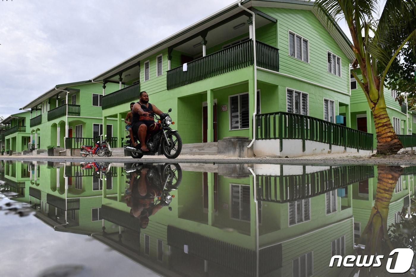 투발루의 한 남성이 오토바이를 타고 물 웅덩이가 고인 투발루 푸나푸티의 도로를 지나고 있다. 2019.08.13 ⓒ 로이터=뉴스1 ⓒ News1 정지윤 기자