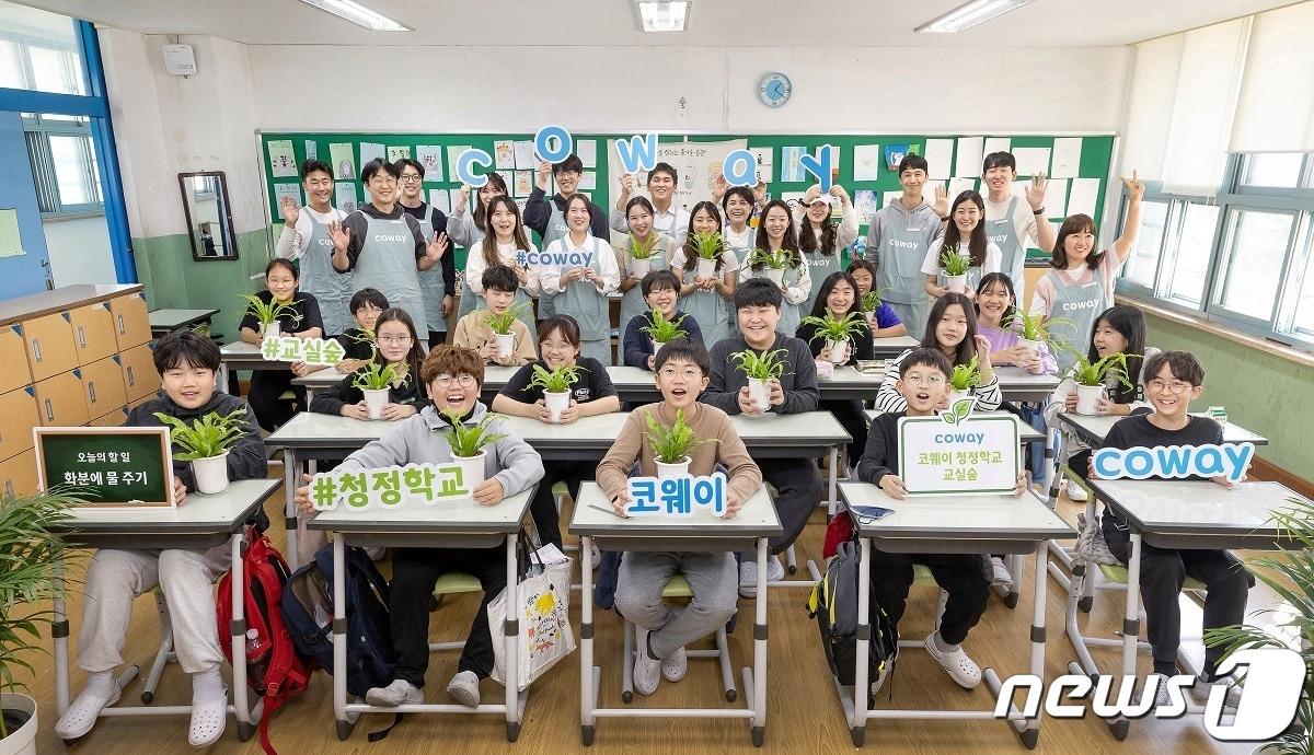 본문 이미지 - 코웨이 임직원 자원봉사단과 학생들이 '코웨이 청정학교 교실숲' 활동을 하며 기념촬영을 하고 있다.(코웨이 제공)