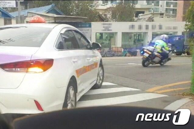 본문 이미지 - 수능일인 16일 오전 부산경찰청 싸이카(오토바이)가 수험생이 타고 있는 택시를 에스코트하고 있다.(부산경찰청 제공)