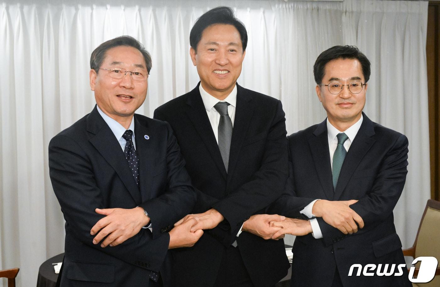 본문 이미지 - 경기도가 추진 중인 산하 공공기관의 경기 북부 이전이 ‘김포시, 서울 편입’ 논란과 맞물려 혼선을 빚고 있다. 사진은 유정복 인천시장, 오세훈 서울시장, 김동연 경기도지사(왼쪽부터)가 16일 오후 서울 중구 프레스센터에서 가진 3자 회동에 앞서 손을 맞잡고 있는 모습. (공동취재) 2023.11.16/뉴스1 ⓒ News1 김도우 기자