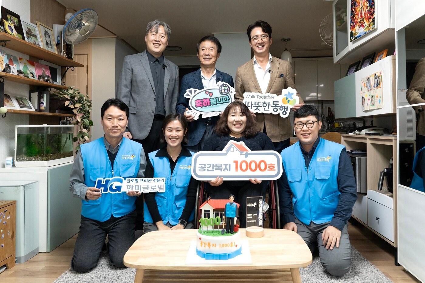 본문 이미지 -  김종훈 따뜻한동행 이사장(윗줄 가운데)과 정준호 후원회장 등이 장애인 공간복지 지원사업 1000번째 수혜 가구 구성원과 함께 기념사진을 찍고 있다. /한미글로벌 제공