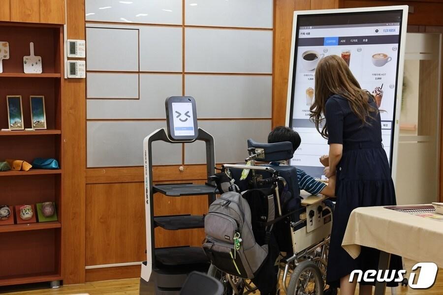 본문 이미지 - 광주새롬학교 배민 서빙로봇 체험하는 모습(비-로보틱스 제공) 