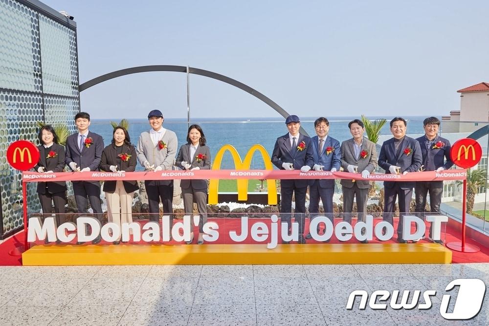 본문 이미지 - 한국맥도날드 임직원들과 관계자들이 23일 제주외도DT점 오픈을 기념해 3층 루프탑 공간에서 테이프 커팅식을 진행하고 있다 &#40;왼쪽에서 다섯 번째 김기원 대표이사&#41;.&#40;한국맥도날드 제공&#41;