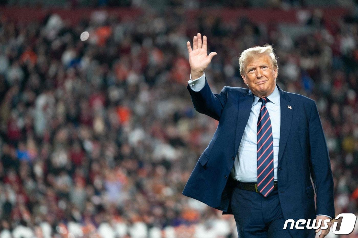 도널드 트럼프 전 미국 대통령이 지난달 25일&#40;현지시간&#41; 사우스캐롤라이나주 컬럼비아에서 열린 대학 미식축구 경기 하프타임 동안 그라운드서 관중에게 손을 흔들고 있다. 2023.11.27 ⓒ AFP=뉴스1 ⓒ News1 우동명 기자