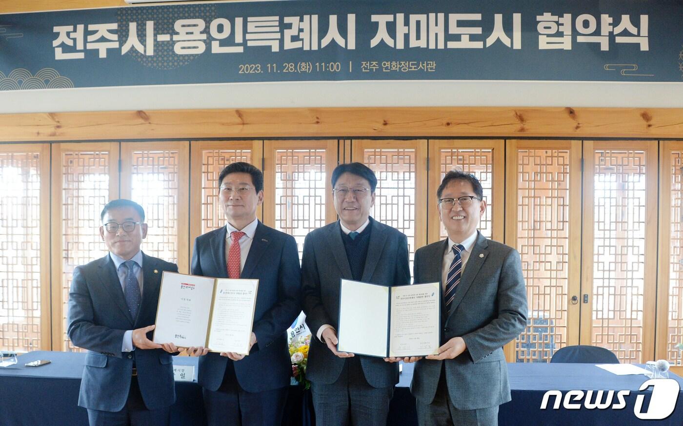 본문 이미지 - 우범기 전주시장(왼쪽에서 세번째)과 이상일 용인특례시장(왼쪽에서 두번째)이 28일 전북 전주시 전주덕진공원 연화정 도서관에서 열린 '전주시-용인특례시 자매도시 협약식'에 참석해 협약식을 마치고 기념촬영을 하고 있다. 2023.11.28/뉴스1 ⓒ News1 유경석 기자